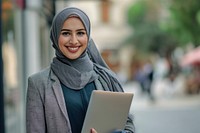 Muslim business woman holding a laptop smiling scarf smile. AI generated Image by rawpixel.