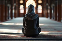 Muslim woman sitting and praying in Mosque adult cross-legged spirituality. AI generated Image by rawpixel.