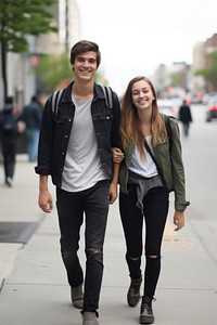 A teen couple walking in the street footwear jacket jeans.