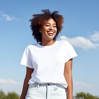 Woman wearing white t-shirt laughing outdoors smiling.