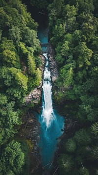 Aerial top down view of stunning waterfall landscape outdoors woodland.