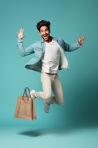 Happy young hispanic man jumping and holding a shopping bag adult men celebration.