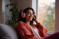 South Asian woman headphones listening sitting. AI generated Image by rawpixel.