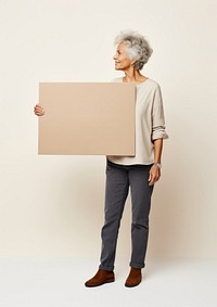 A mature woman holding a cardboard sign standing portrait person. AI generated Image by rawpixel.
