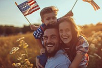 A joyful family with America flags portrait outdoors adult.