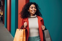 Happy young Latin lady holding shopping bags adult coat architecture.