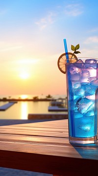  Summer blue soft drink on counter with sunset background cocktail outdoors mojito. 