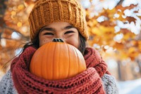 A girl with funny costume holding halloween pumpkin sweater face jack-o'-lantern.