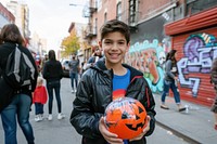 A kid with funny costume holding halloween pumpkin football sports adult.