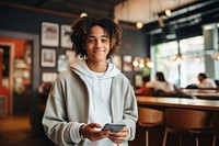 Teenager in streetwear at a cafe with a tablet at cashier smiling adult photo.