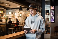 Teenager in streetwear at a cafe with a tablet at cashier waiter entrepreneur architecture.