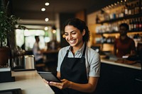 A woman at a cafe with a tablet at cashier smiling adult entrepreneur.