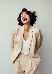 A happy mixed race korean woman wear cream casual suit laughing fashion adult.