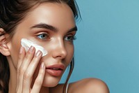 Woman applying skin face cream cosmetics adult cheek.