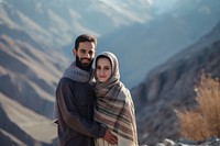 Middle eastern couple standing in mountain together portrait outdoors smiling.