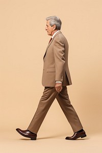 A senior man walking in studio wearing suit adult khaki side view.