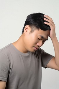An east asian man suffering from headache portrait photo pain.