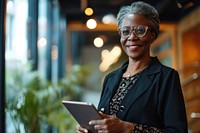 Black business middle-aged woman smiling whild holding a tablet glasses adult electronics. AI generated Image by rawpixel.
