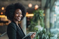 Black business woman smiling whild holding a tablet computer smile adult. AI generated Image by rawpixel.