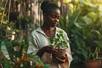 Black woman taking care of a plant pot outdoors garden agriculture. AI generated Image by rawpixel.