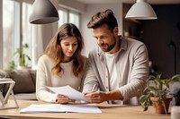 Young couple holding and looking at paperwork stock photo conversation adult togetherness.