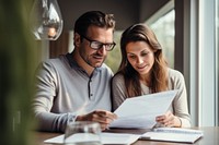 Young couple holding and looking at paperwork stock photo conversation document adult.