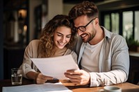 Young couple holding and looking at paperwork stock photo document adult fun.