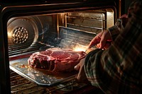 Pulling out steak from the oven appliance cooking person.