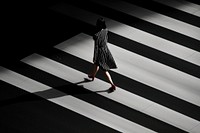 A minimalistic photography of a lady crossing the road on busy hour advertisment style adult monochrome pedestrian.