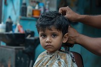 Indian boy getting a haircut in barber baby hairdresser innocence.