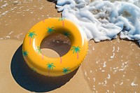 Tropical printed swimming ring on beach