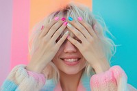 Woman covering her eyes manicure smiling blonde.