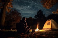 Young alone people and their pets camping in autumn night fire outdoors.