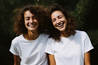 Two diverese women wearing white t-shirt smiling laughing smile adult.