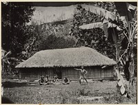 Man posed in front of hut