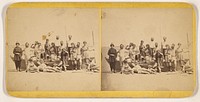 Group of people posed in a rowboat on shore by C G Gooding