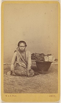 Javanese woman seated with legs crossed, basket at side by Woodbury and Page