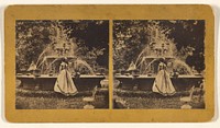 Woman in long dress with back to the camera viewing a spraying fountain, probably at Vinton, Iowa by Henry A Jordan