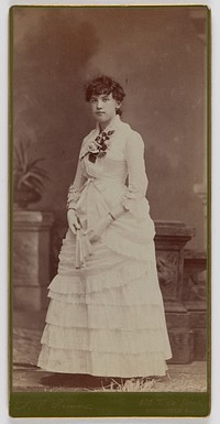 Unidentified young woman in long white dress, standing by Aldin V Brown