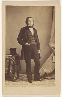 Unidentified man with muttonchops, standing with his right hand in pocket, top hat on table by Bailly and Maurice