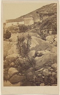 Unidentified rocky landscape with two people and houses in the background