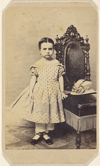 Unidentified little girl wearing a polka dot dress, standing