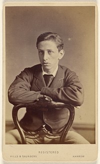 Unidentified young man seated, with arms on chair back by Hills and Saunders