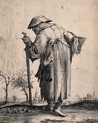 An old beggar-man leaning on a stick and carrying a basket is walking towards a town in the distance. Etching.