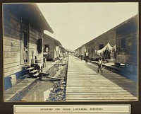 Panama Canal workers' (West Indian and Panaman) quarters: exterior view of wooden huts with resident children in foreground. Photograph, ca. 1910.