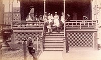 Bellevue Hospital, New York City: children patients, nurses and doctors sitting on a balcony in the sunshine. Photograph.
