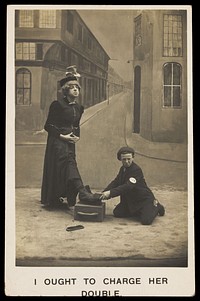 A shoeshine boy cleans the boots of a man in drag. Photographic postcard, ca. 1905.