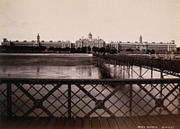 Netley Hospital, Hampshire, England: exterior view showing soldiers on the bridge in the foreground. Photograph, ca. 1880 .