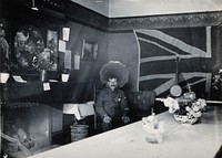 Holmleigh Auxiliary Military Hospital, Harrow: a soldier with amnesia sitting in a room with a huge Union Jack flag on the wall in the background. Photograph, c. 1922.