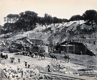 Menufia Canal, Egypt: reconstruction work to the first Aswan Dam: men at work and camels transporting materials. Photograph by D. S. George, 1910.